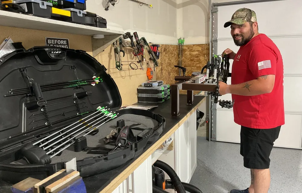 Technician inspecting a compound bow on the shop workbench