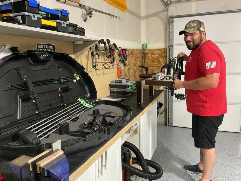 Jahnke Northwest Archery technician tuning a compound bow on the shop workbench